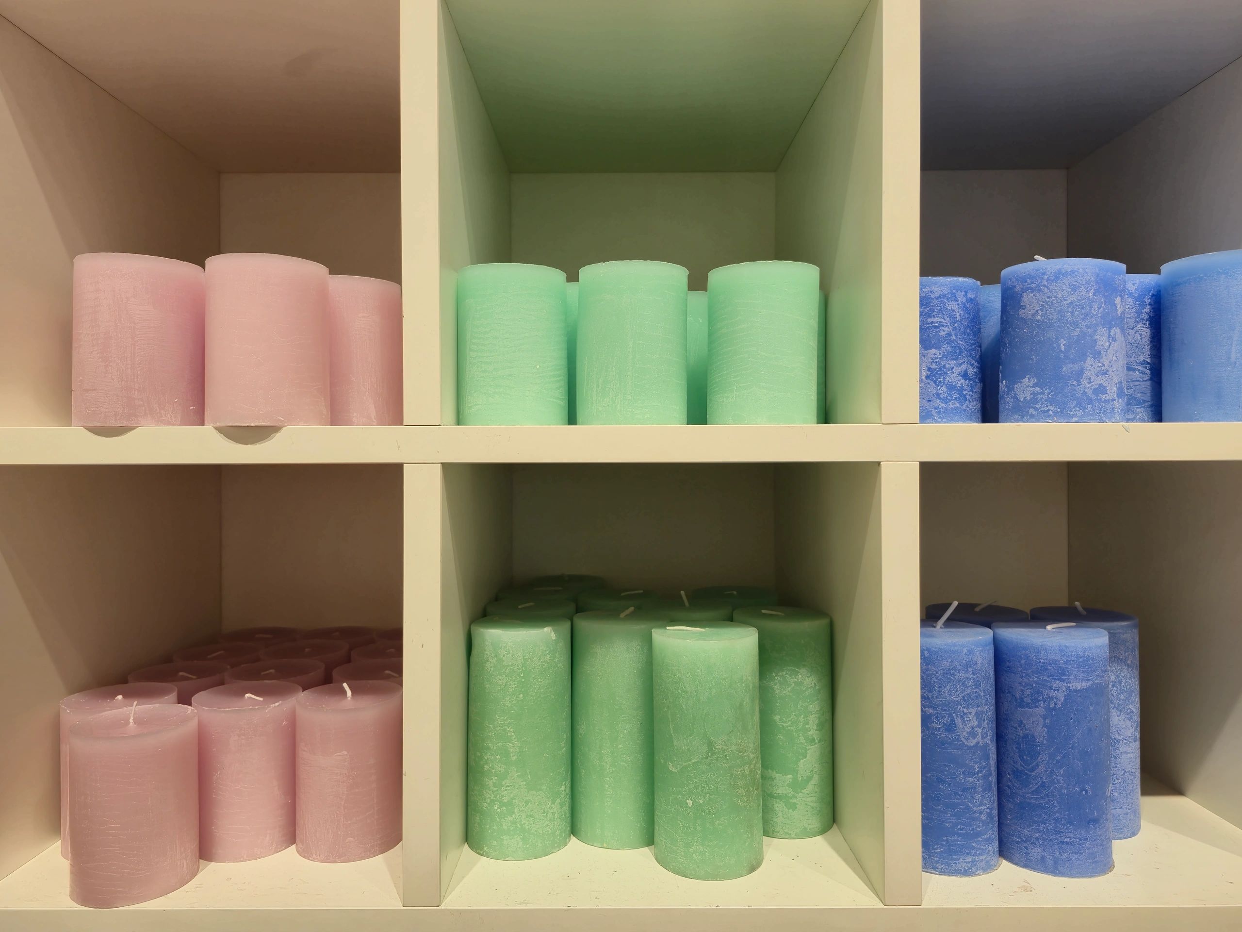 Colorful candles displayed on wooden shelves