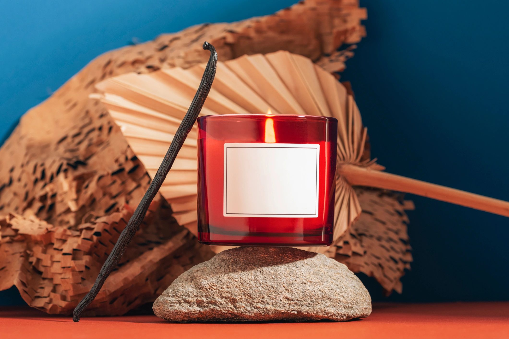 Lit candle styled on a modern pedestal with soft decor